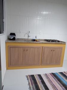 a kitchen with a sink and a counter top at Casa aconchegante próxima a praia in Laguna