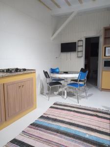 a kitchen and dining room with a table and chairs at Casa aconchegante próxima a praia in Laguna +6 photos