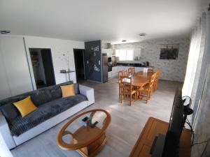 ein Wohnzimmer mit Sofa und Tisch in der Unterkunft Maison plain-pied au calme proche lac de miel Wifi gratuit in Beynat