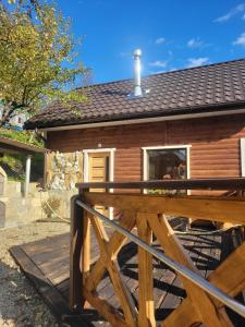 a small wooden cabin with a wooden deck at Забрус насолоди in Kosiv