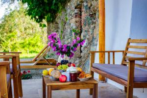 une table avec un bol de fruits et un vase de fleurs dans l'établissement Suite du Domaine Marquiliani, à Fautea