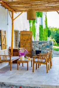 un patio avec deux bancs, une table et des chaises dans l'établissement Suite du Domaine Marquiliani, à Fautea