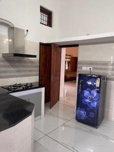 a kitchen with a refrigerator with a flower painted on it at Wayanad Midnight Oasis in Meenangadi