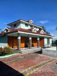 a house with a patio in front of it at Wayanad Midnight Oasis in Meenangadi