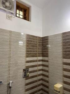 a bathroom with a shower with brown tiles at Wayanad Midnight Oasis in Meenangadi +34 photos