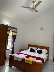 a bedroom with a bed with a ceiling fan at Wayanad Midnight Oasis in Meenangadi