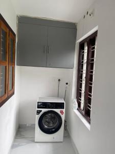 a kitchen with a washing machine in a room at Wayanad Midnight Oasis in Meenangadi