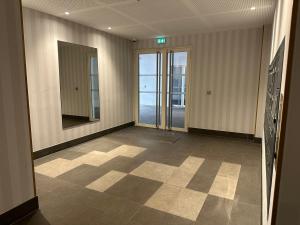 an empty room with a hallway with glass doors at Classy apartment with terrace in Saint-Ouen