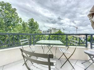 a patio table and chairs on a balcony at Classy apartment with terrace in Saint-Ouen