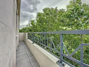a balcony with a blue railing and trees at Classy apartment with terrace in Saint-Ouen +8 photos
