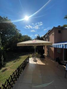 a patio with an umbrella and a table and chairs at Bosa House in Belgrade