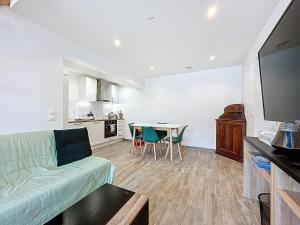 a living room with a couch and a table at Maisonnette 36m2 à 5 minutes de Chantilly in Vineuil-Saint-Firmin