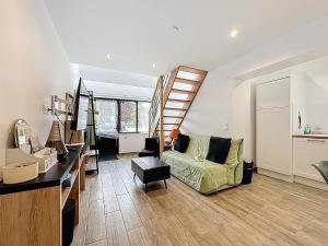 a living room with a staircase and a couch at Maisonnette 36m2 à 5 minutes de Chantilly in Vineuil-Saint-Firmin