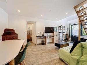a living room with a couch and a table at Maisonnette 36m2 à 5 minutes de Chantilly in Vineuil-Saint-Firmin +6 photos