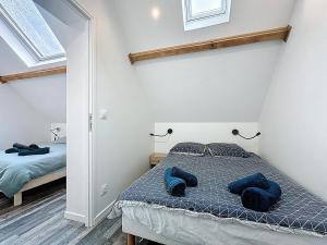 a bedroom with a bed with blue pillows on it at Maisonnette 36m2 à 5 minutes de Chantilly in Vineuil-Saint-Firmin