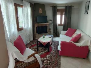 a living room with two couches and a table at Thodoris Apartment's in Eptalofos