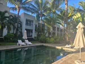 カップ・マルールーにあるLa Residence Sea Horse and Seashell Beachfront Apartment 23のヤシの木が植わるリゾートです。
