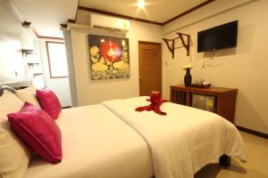 una camera da letto con un letto bianco e un orsacchiotto sopra di TR Guesthouse a Sukhothai