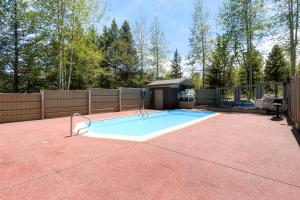 a large swimming pool in a backyard with a fence at Ski Hill 15 by Ski Country Resorts in Breckenridge