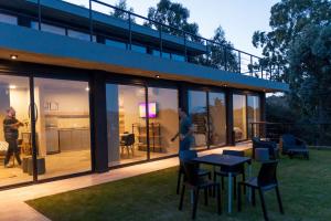 a house with glass doors and a person playing a video game at LUNALBA in Potrero de Garay