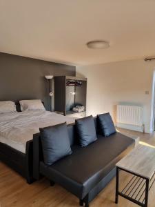 een slaapkamer met een bed en een bank met blauwe kussens bij Rock Ridge Villa in Abertillery