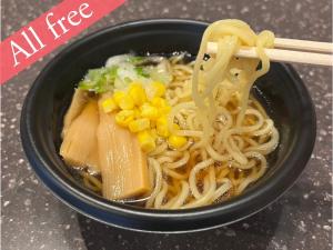 a bowl of noodles and vegetables with a pair of chopsticks at Anshin Oyado Woman&Man Nagoya Sakae in Nagoya