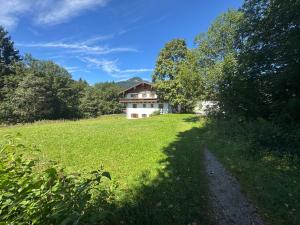 a house in the middle of a grassy field at ciao-aschau Grenzhub FeWo 312 Göke in Aschau