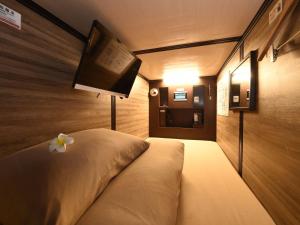 a bedroom with a bed with a flat screen tv at Anshin Oyado Woman&Man Nagoya Sakae in Nagoya