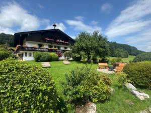 un bâtiment dans un champ planté d'arbres et d'herbe dans l'établissement ciao-aschau Gschwendtnerhof Ap26 Faust, à Aschau