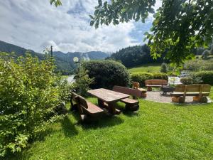 une table de pique-nique et des bancs assis dans l'herbe dans l'établissement ciao-aschau Gschwendtnerhof Ap26 Faust, à Aschau