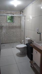 a bathroom with a toilet and a shower and a sink at A home away from home in Ijuí +2 photos