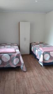 two beds sitting next to each other in a room at A home away from home in Ijuí