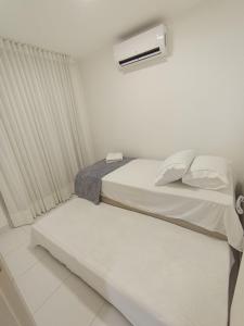 une chambre blanche avec un lit et une fenêtre dans l'établissement Metropolitan Barcelona Flamboyant Autódromo Serra Dourada Aeroporto 6 hospedes 2 garagens 3 ares condicionados, à Goiânia