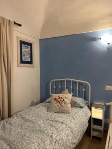 une chambre avec un lit avec un mur bleu dans l'établissement La petite maison Fleur, à Biella 17 autres photos