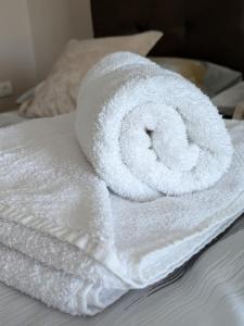 a roll of white towels sitting on top of a bed at Rivera Raška in Raška