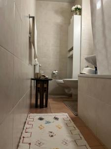 a bathroom with a toilet and a table with a rug at Champel Cozy Studio in Geneva