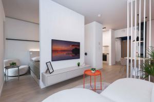 a living room with a tv on a wall at Metropolis- brand new apartment with free parking in Nivy