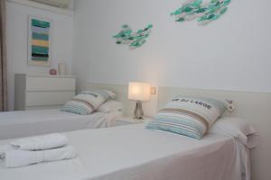 two beds in a white room with white sheets and pillows at Harmony Seafront 365 by Can Ventet in Port de Pollensa
