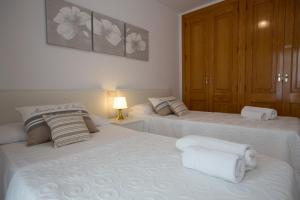 two beds in a bedroom with white towels on them at Harmony Seafront 365 by Can Ventet in Port de Pollensa
