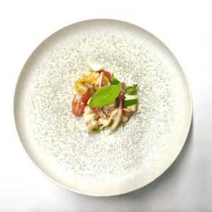 a white plate of food on a white table at Locanda Marco in Bellinzona +10 photos