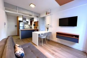 a living room with a couch and a table and a tv at Apto Design Moderno no Centro in Florianópolis
