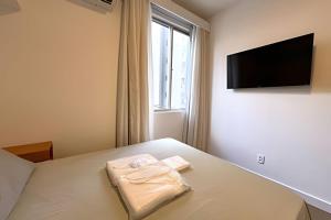 a bedroom with a bed with a television on the wall at Apto Design Moderno no Centro in Florianópolis