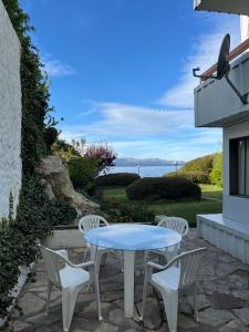 a table and chairs on a patio with a view of the ocean at Departamento Costa del Lago Bariloche in San Carlos de Bariloche