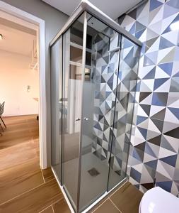 a glass elevator in a room with a geometric wall at Apto Design Moderno no Centro in Florianópolis