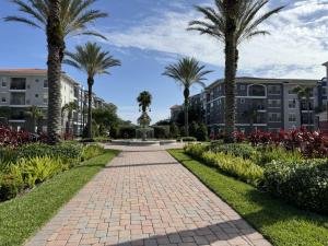 a brick pathway with palm trees and buildings at Vista Cay Getaway Luxury By Universal Orlando Rent in Orlando