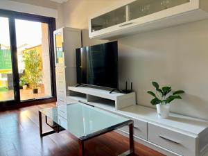 a living room with a tv and a glass table at Descanso Sol y Mar O Grove in O Grove