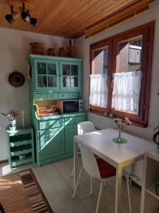 une cuisine avec des armoires vertes et une table blanche dans l'établissement Ferienwohnung Aragon M88, à Ernen 7 autres photos