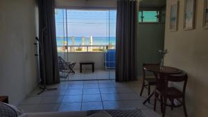 a living room with a view of the ocean at Pousada Areia e Mar in Ubatuba