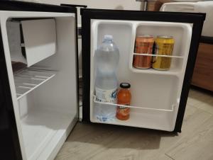 een open koelkast met een fles water en andere dranken bij GiGi Affittacamere in Siracusa