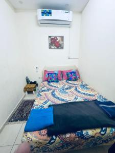 um quarto com uma cama com um cobertor colorido em Budget Hostel Rooms em Al Ain